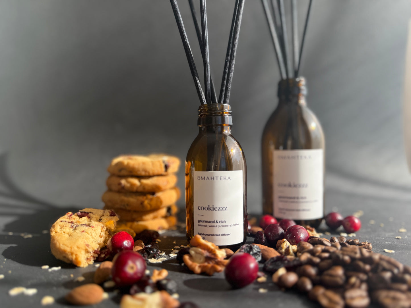 Difuzorul Cookiezzz de la Omahteka, plasat într-un decor cozy de iarnă, cu cookies și bețișoare negre din ratan.