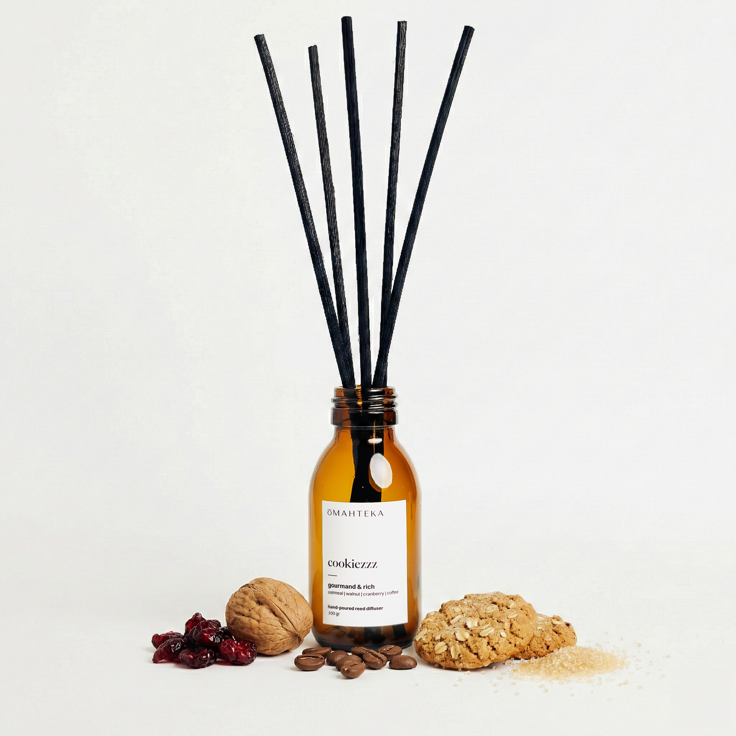 Difuzorul Cookiezzz de la Omahteka, plasat într-un decor cozy de iarnă, cu cookies și bețișoare negre din ratan.