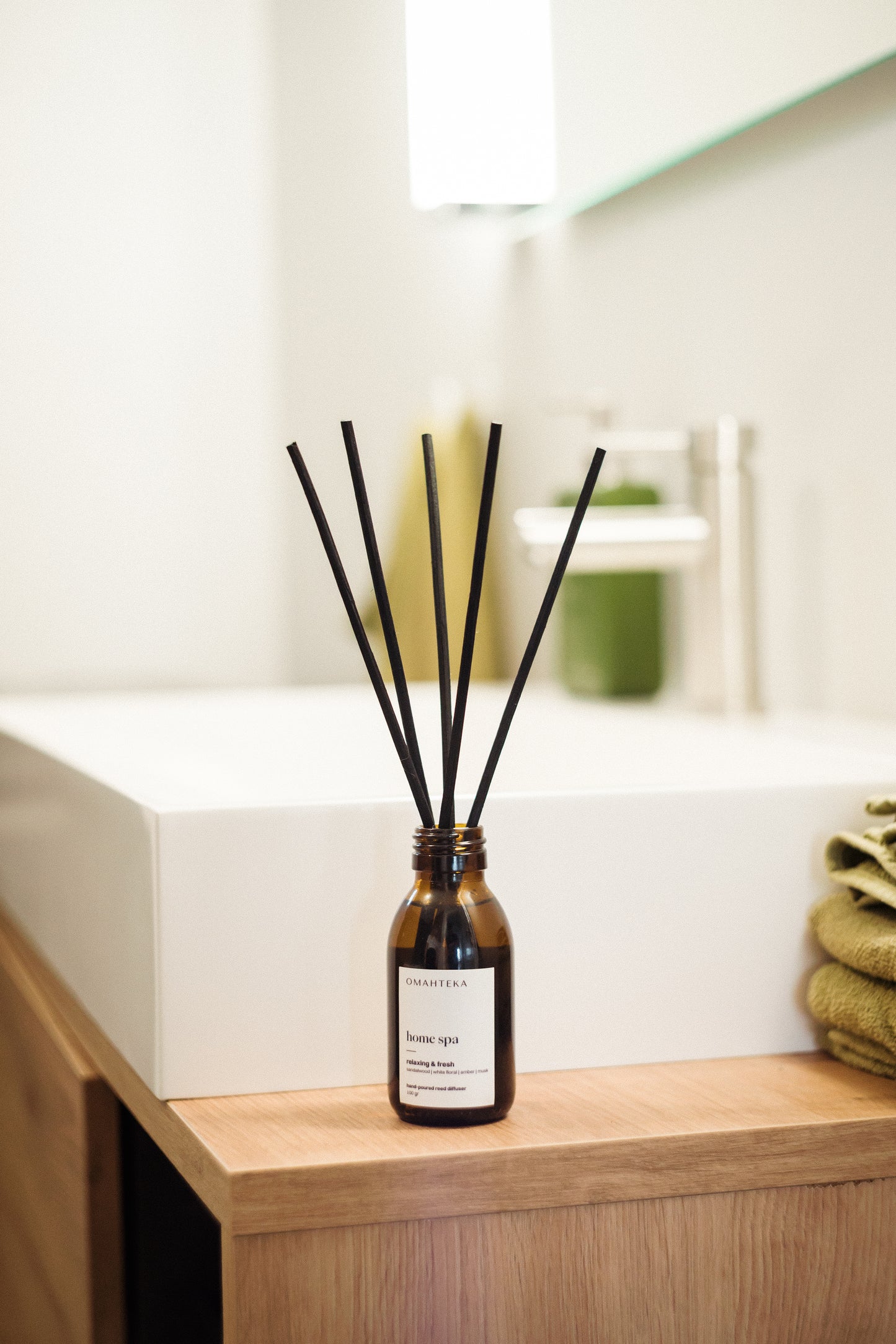 Detaliu difuzor Home Spa de la Omahteka - bețișoarele din ratan eliberează constant aroma caldă de lemn de santal, ambră și mosc, creând o atmosferă relaxantă de spa în orice cameră.