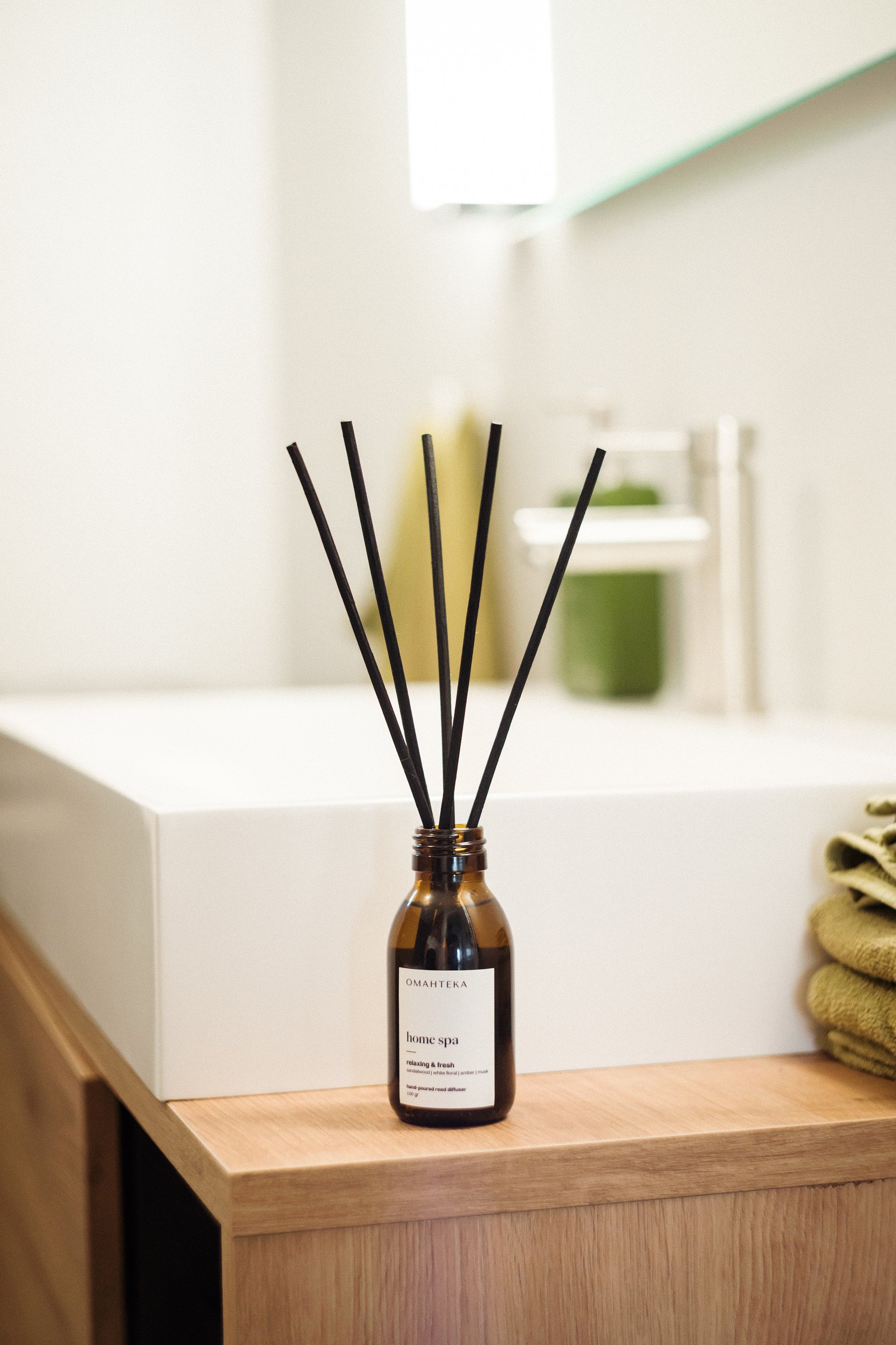 Detaliu difuzor Home Spa de la Omahteka - bețișoarele din ratan eliberează constant aroma caldă de lemn de santal, ambră și mosc, creând o atmosferă relaxantă de spa în orice cameră.