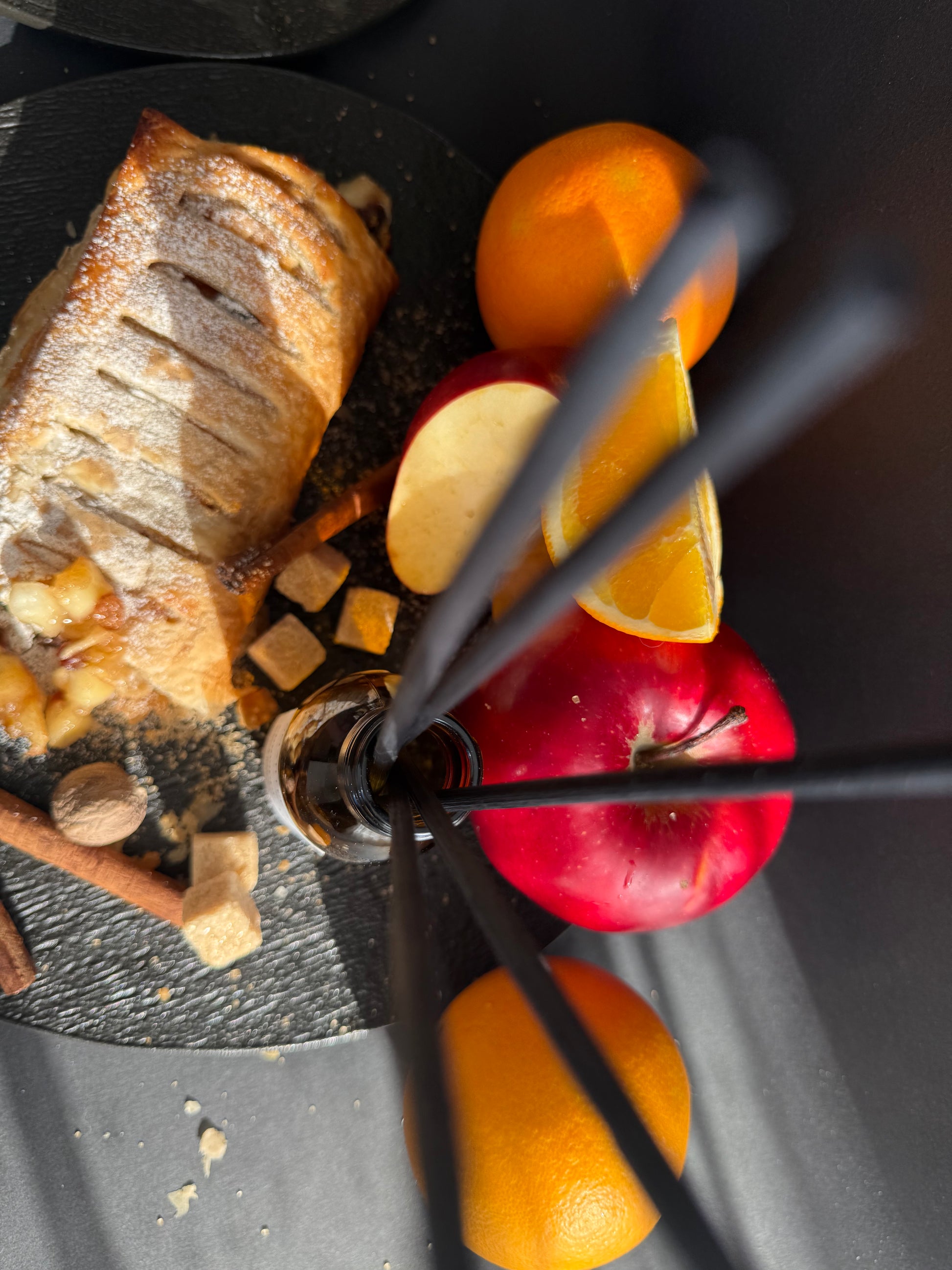 Parfum de cameră în sticlă cu protecție UV, înconjurat de mere, scorțișoară și elemente cozy de iarnă.