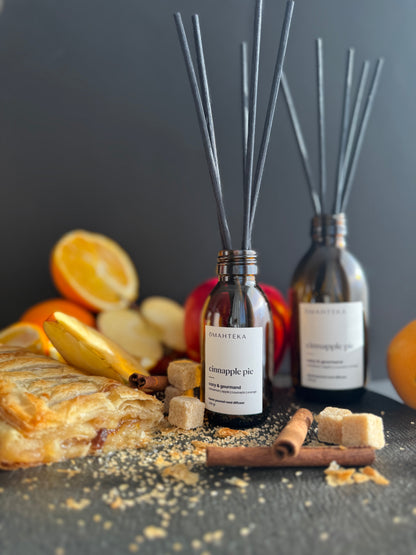 Parfum de cameră cu bețișoare negre, prezentat într-o scenă de iarnă cu note vizuale de mere, scorțișoară și zahăr brun.