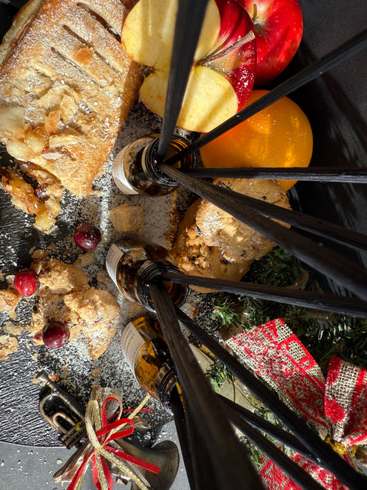 Trio-ul Cookiezzz, Cinnapple Pie și Christmas Tree în sticle cu protecție UV și betișoare negre din ratan, fotografiate într-un setup cozy de iarnă.