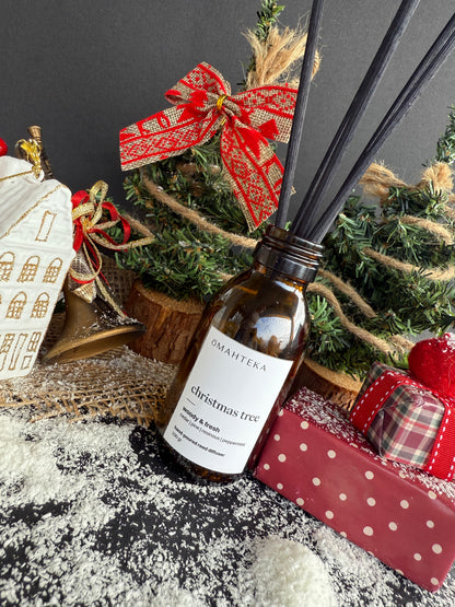 Difuzor Christmas Tree într-un setup de sărbători cu clopoței, luminițe și texturi verzi de iarnă.