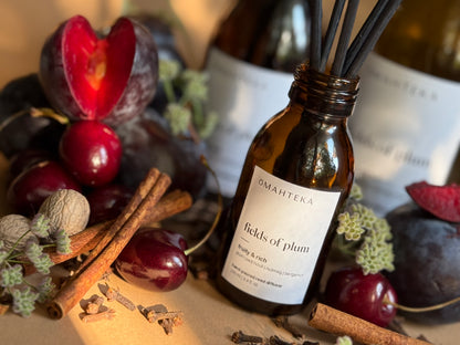 Fields of Plum de la Omahteka – parfum cu bețișoare în sticlă de culoare maro cu protecție UV, în decor cu condimente și cireșe negre.