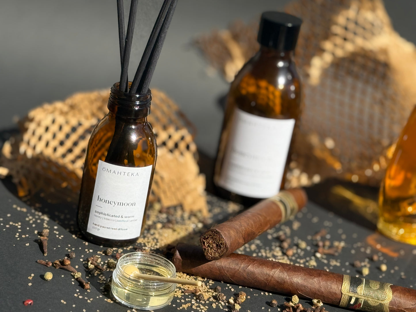 Parfum de cameră Honeymoon de la Omahteka, în sticlă maro cu protecție UV, cu note de miere, tutun și esențe lemnoase rafinate.